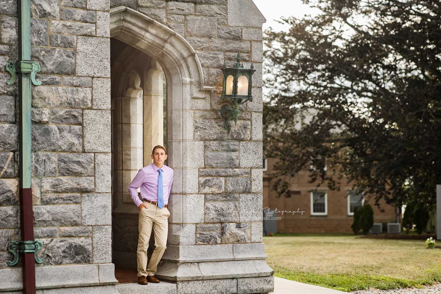 young man leaning against a brick archway, Old Saybrook, CT Senior photographer