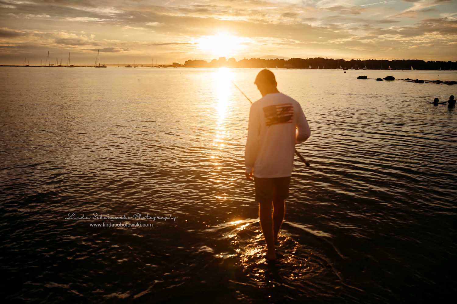 silhouette image of a boy fishing in the water at sunset, CT Senior Boy photography session