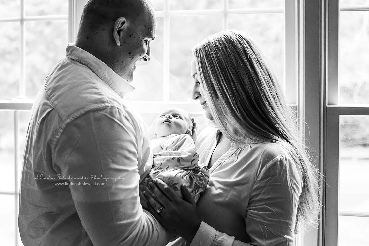 new parents holding their baby girl, Madison, CT lifestyle newborn photographer