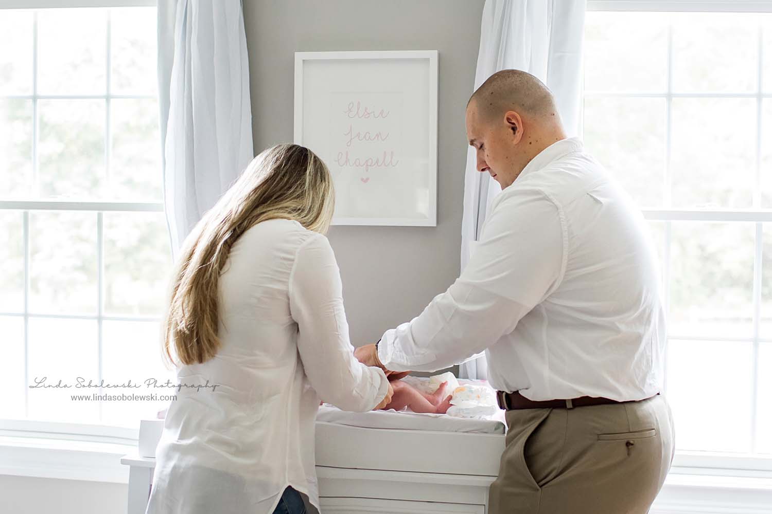 parents changing their baby's diaper, CT family photographer