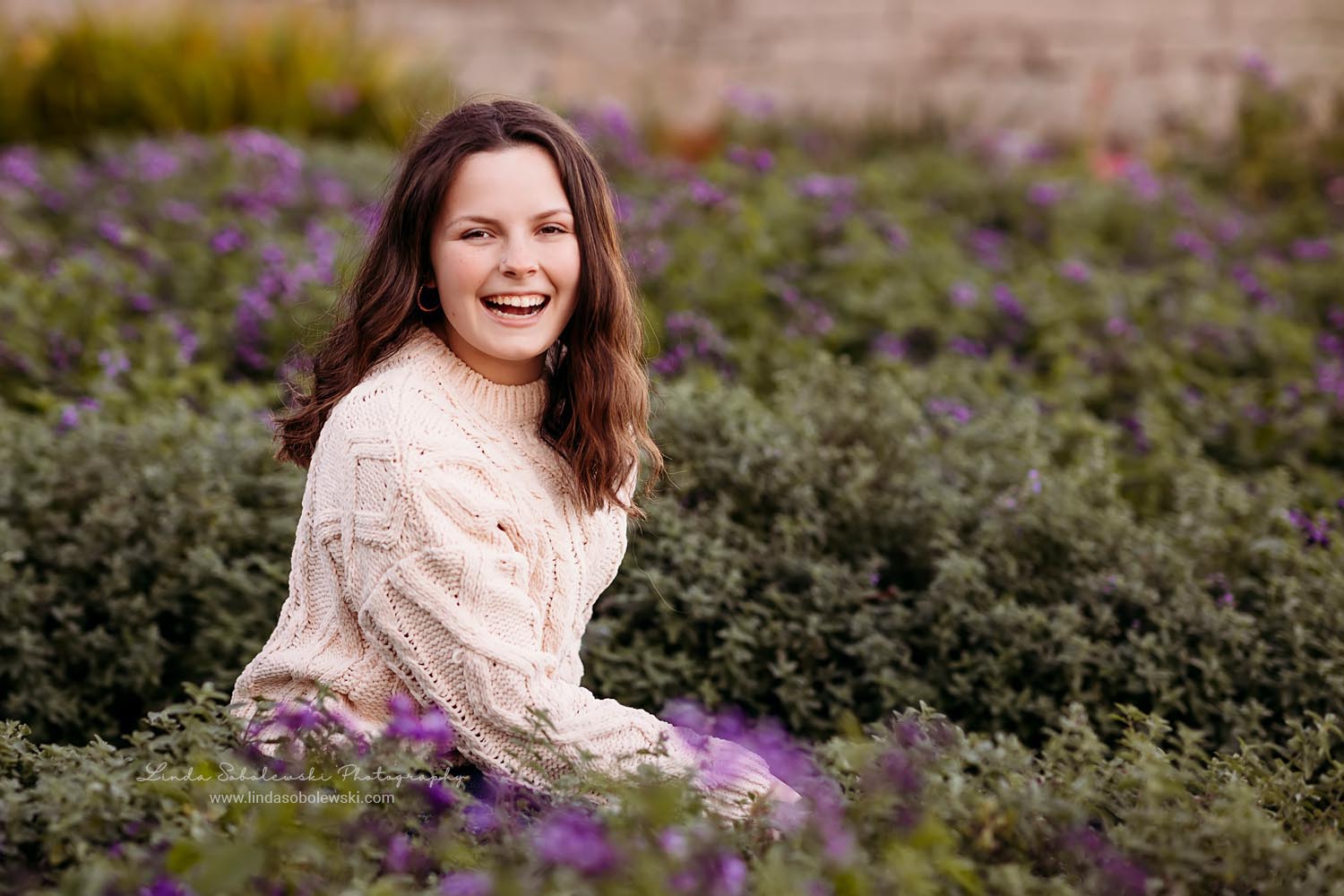 girl in white sweater sitting in the flowers, CT High School Senior Photography Session