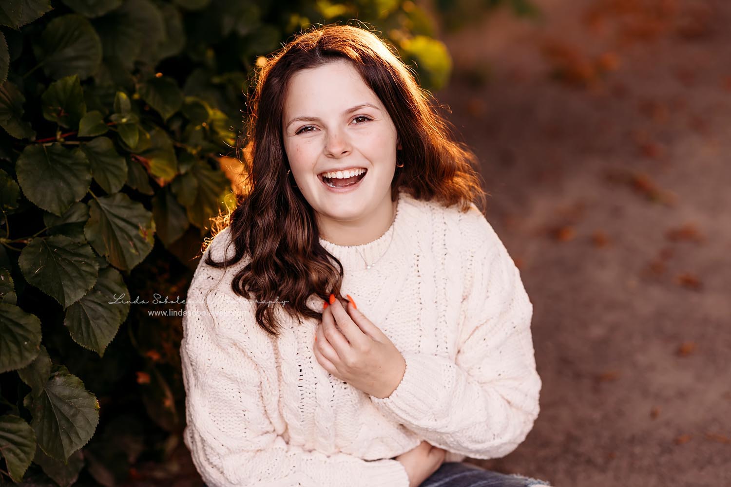 girl in white sweater sitting in the flowers, Senior girls photos at harkness memorial park