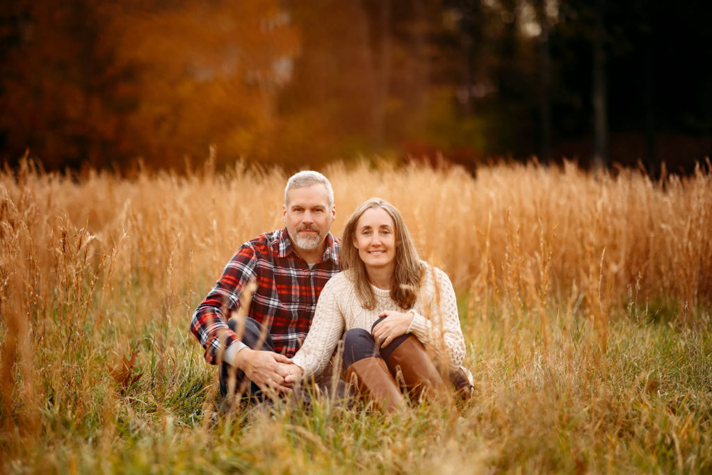 couple sitting in golden grass, Old Lyme, CT photographer