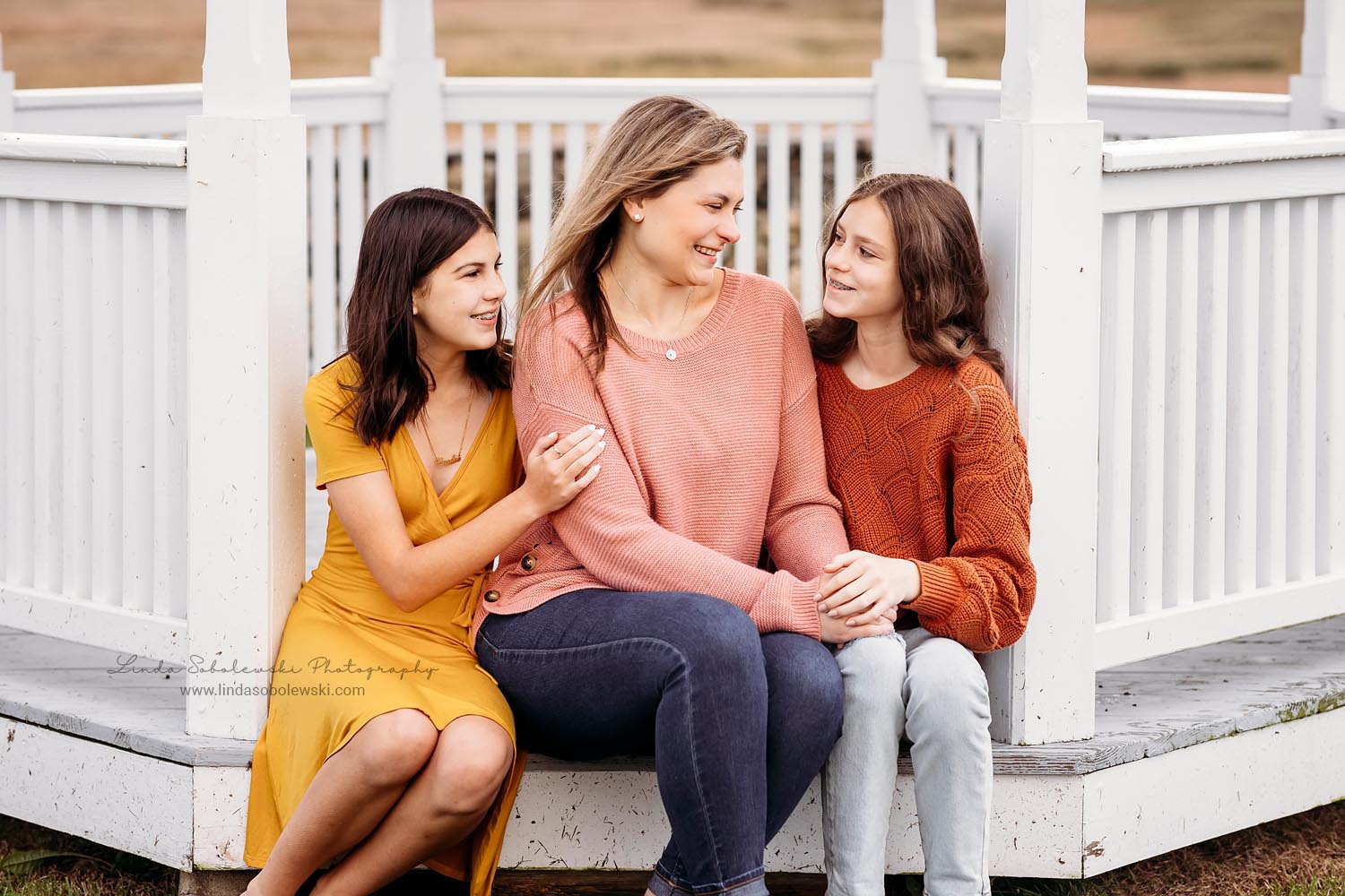 mom in pink sweater sitting with her two daughters, Old Saybrook CT Family Photoshoot