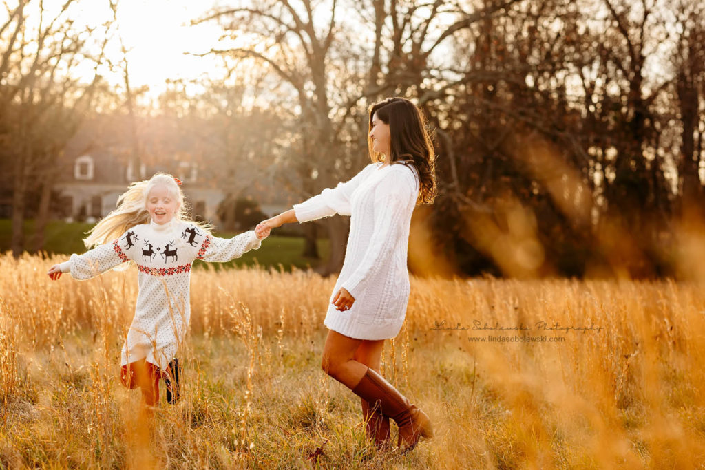 mom and her daughter spinning around in a golden field, Old Saybrook CT photography session