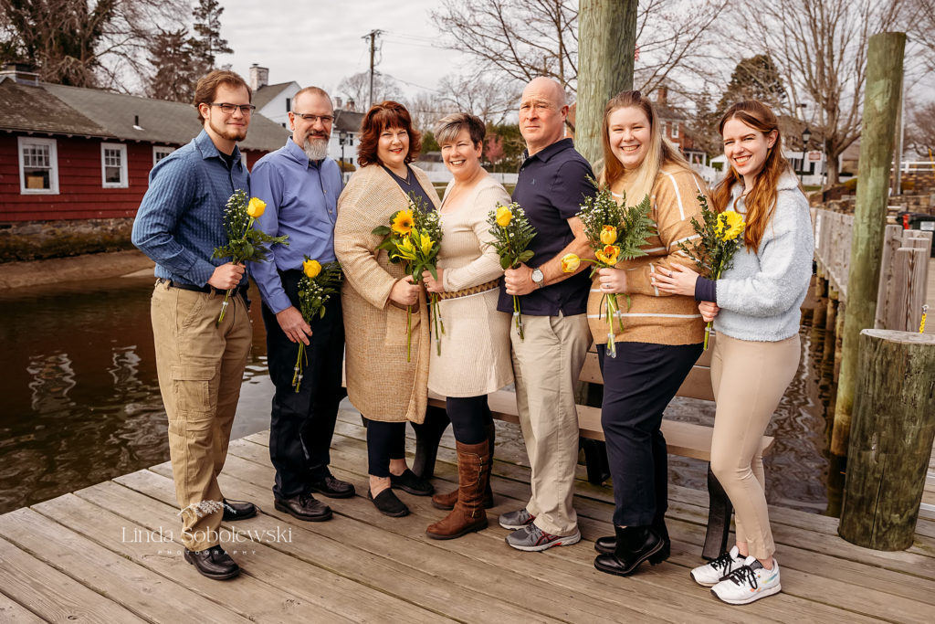 large family holding yellow flowers, Essex, CT shoreline photographer