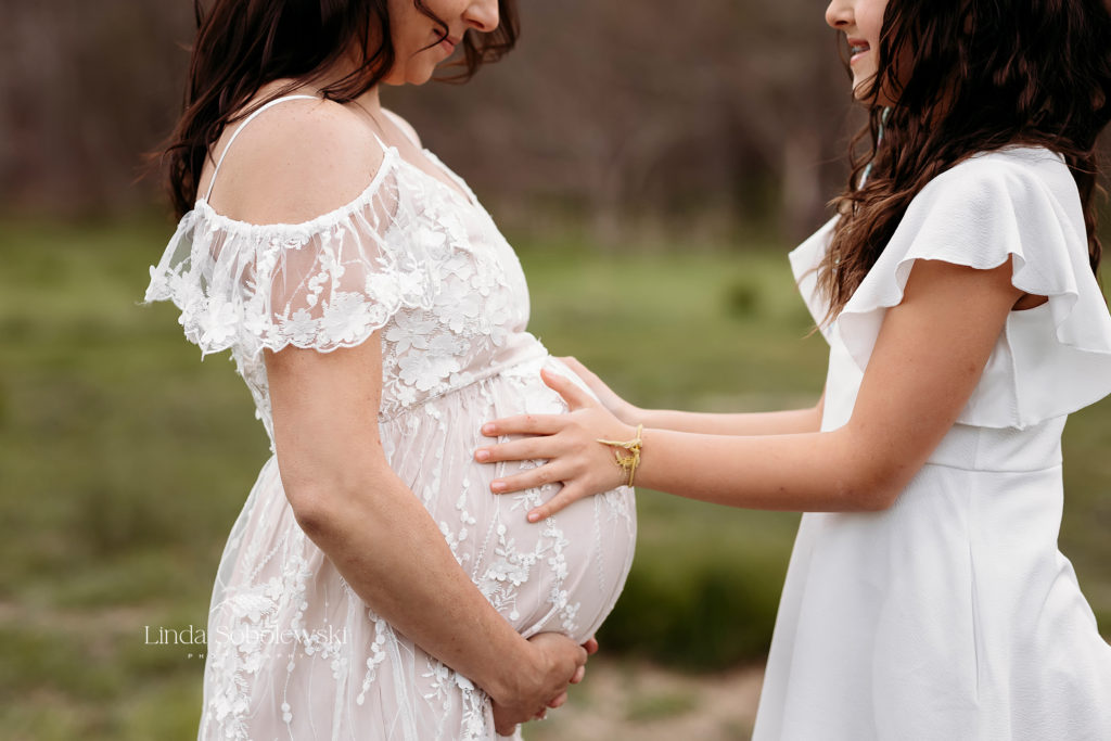 child putting her hands on her expectant mother's belly, CT Shoreline Maternity Session