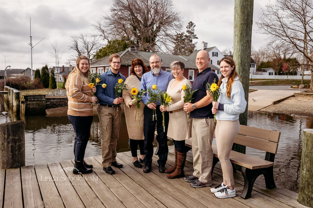 large family holding yellow flowers, Essex, CT shoreline photographer