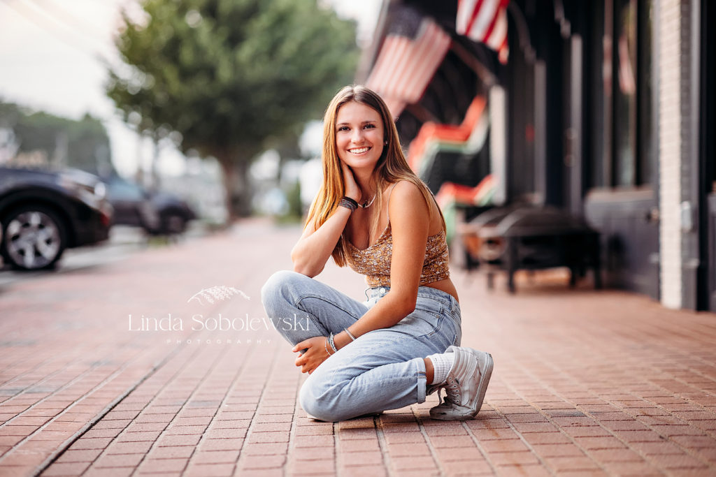 girl sitting on a sidewalk, Urban senior photography session in Old Saybrook, CT