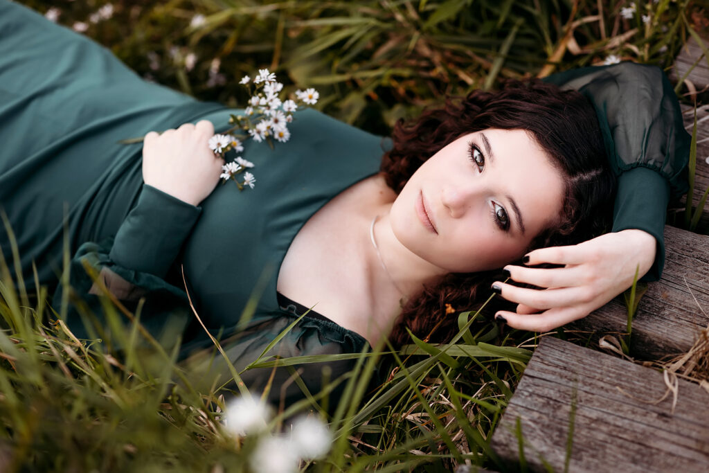 girl in green dress laying in the grass. CT Shoreline Senior photographer