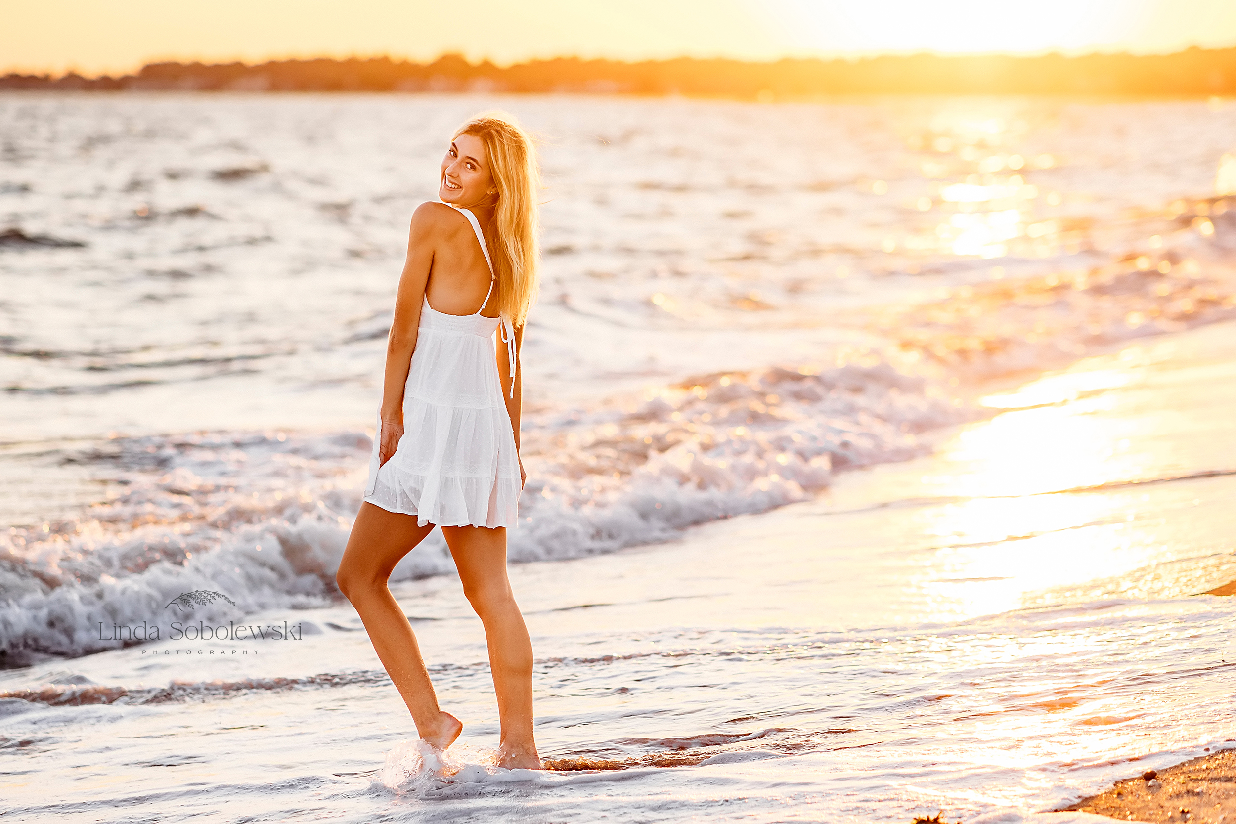 Girl in white dress for gorgeous high school senior photos at the beach in Madison CT