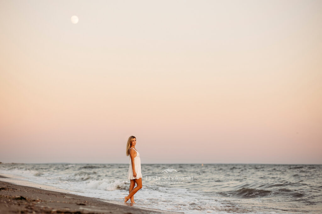 Girl in white dress for gorgeous high school senior photos at the beach in Madison CT