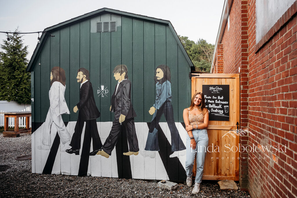 teenage girl standing in front of an mural in downtown Old Saybrook, Urban Senior Photographer
