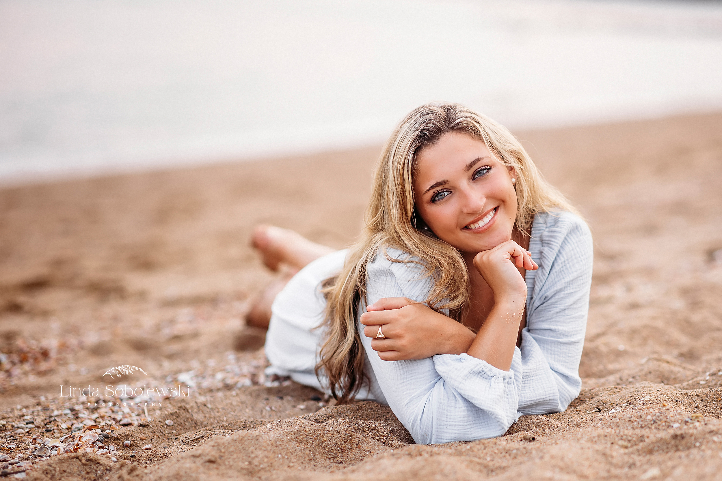 girl in blue dress laying on the beach, senior photos in Madison