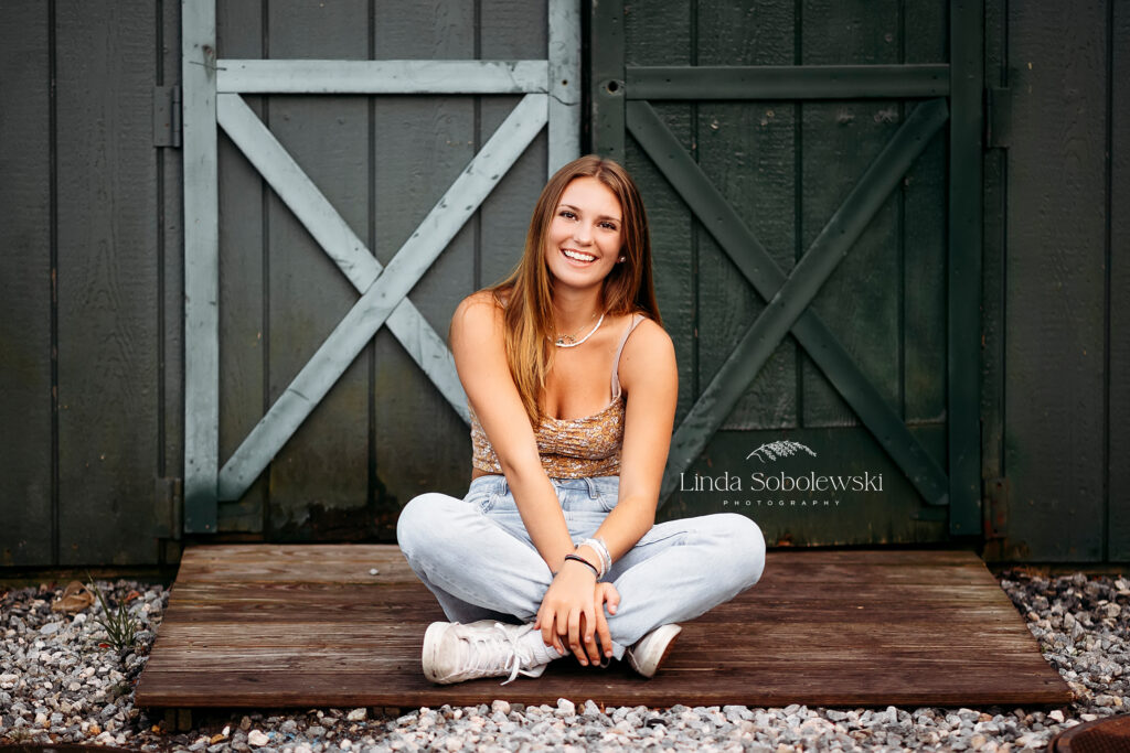 girl sitting in front of a green door, CT shoreline urban senior photo session