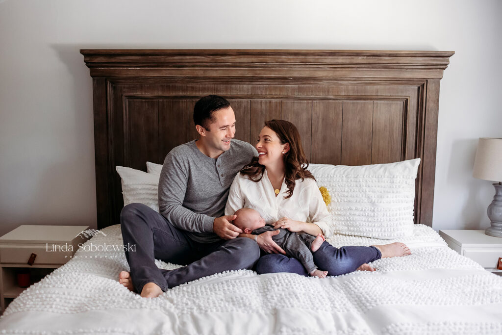 parents in their bed with their new baby boy, CT newborn photographer