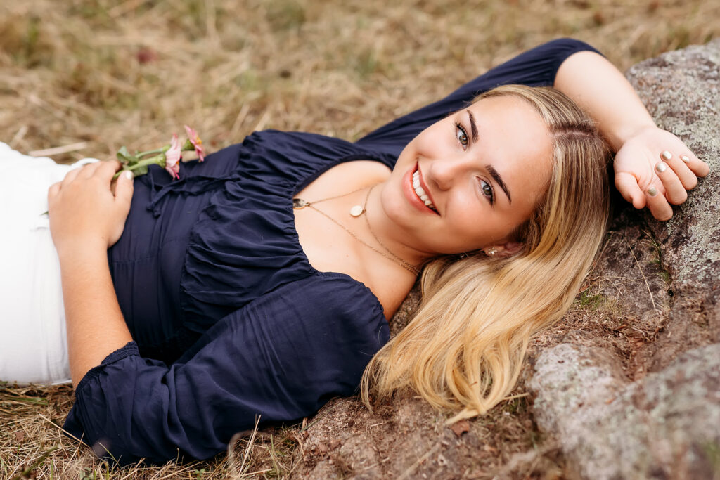 girl in blue top laying on a rock, CT Senior photographer, 2022 session superlatives