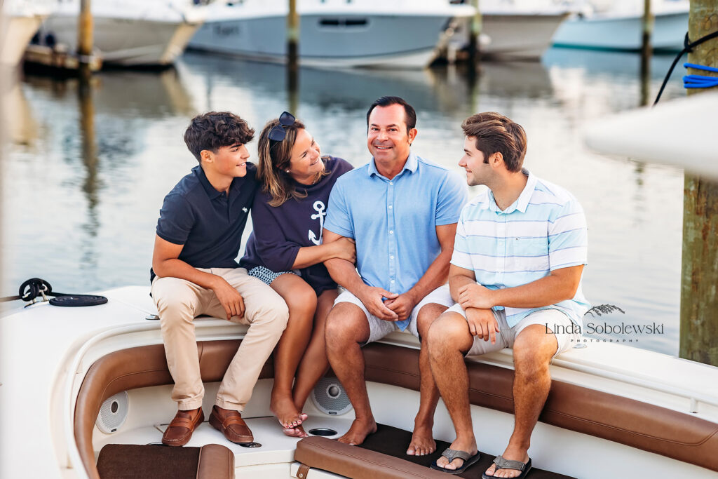 family of four sitting on the family boat, CT Family and senior photographer
