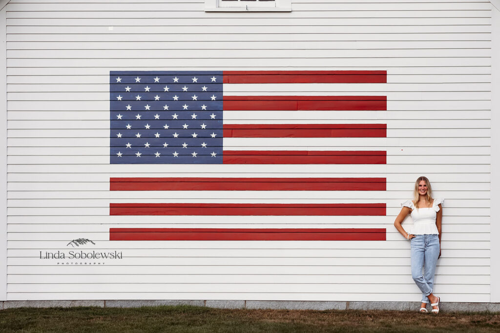 girl standing against a large american flag, Mercy High School Senior portraits session