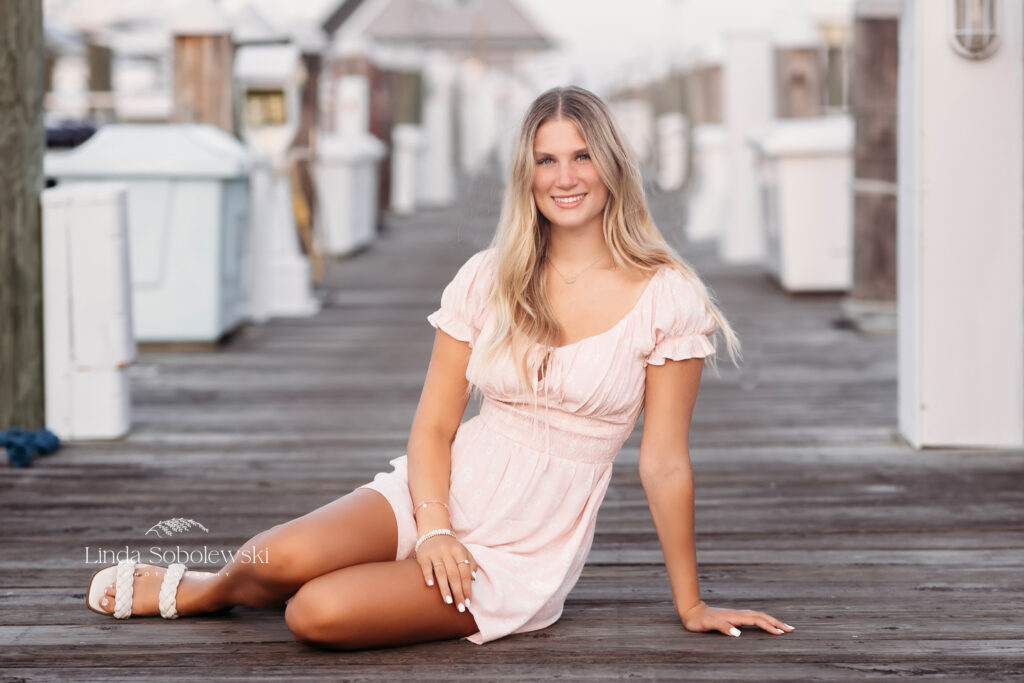 blonde girl in pink dress sitting on a pier, Mercy High School Senior Senior photographer