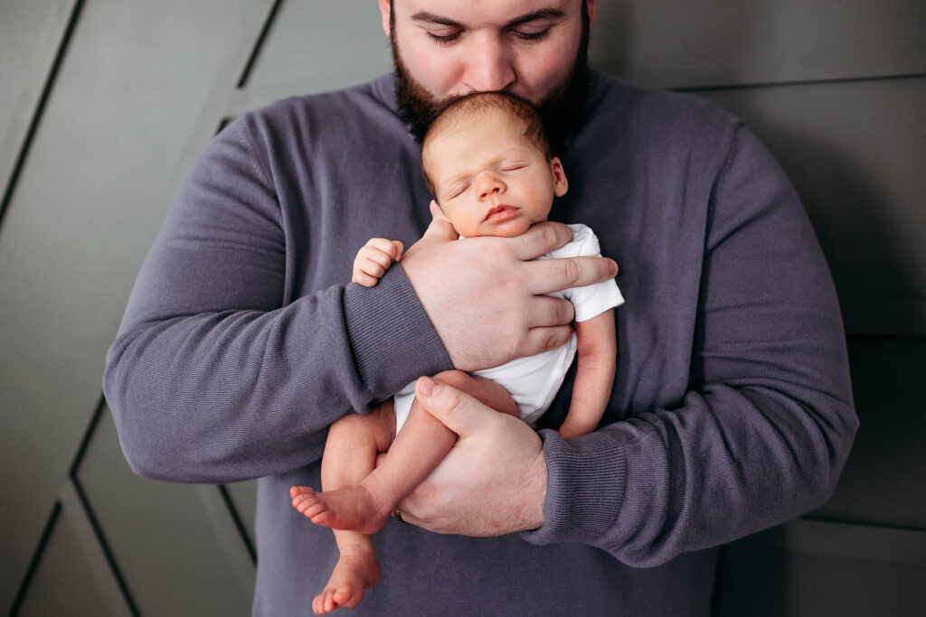 man in grey shirt holding his baby boy, Branford CT Newborn photographer