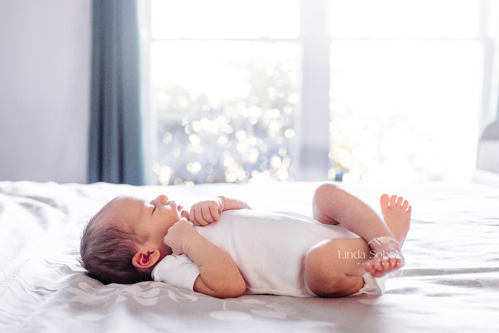 newborn baby girl laying on a bed, CT newborn lifestyle baby photographer