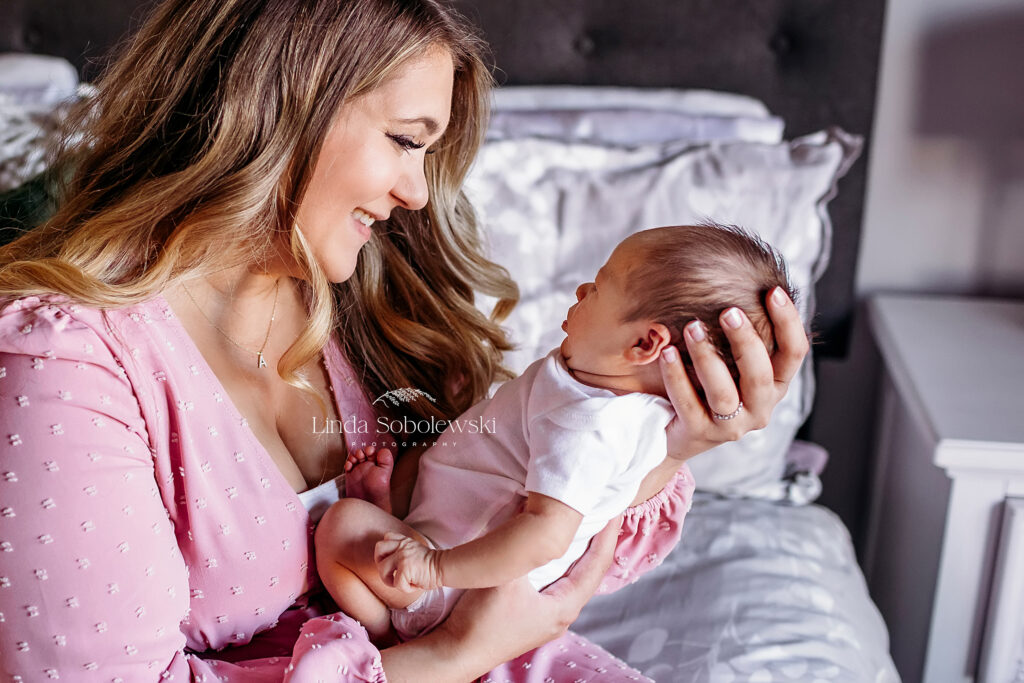 mother in pink dress holding her baby, New England Newborn photographer