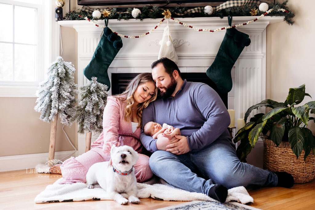 mother and father holding their newborn baby in front of the fireplace, Newborn photographer