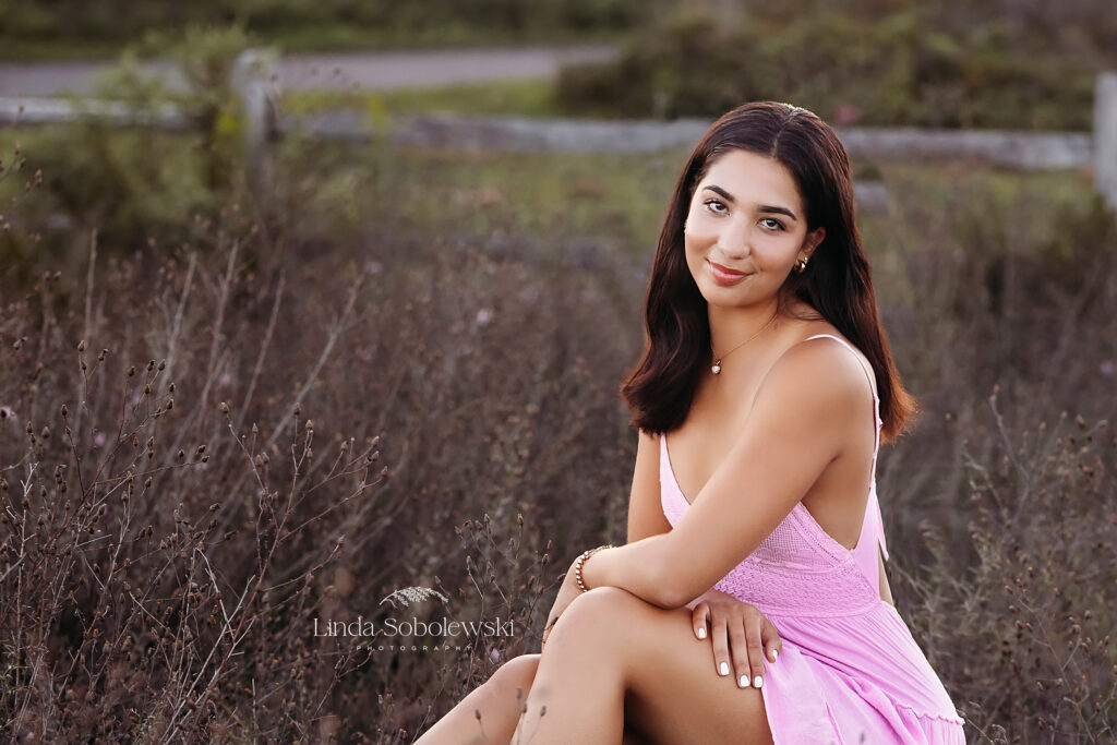 girl in pink dress sitting in a field, Madison CT High school photographer