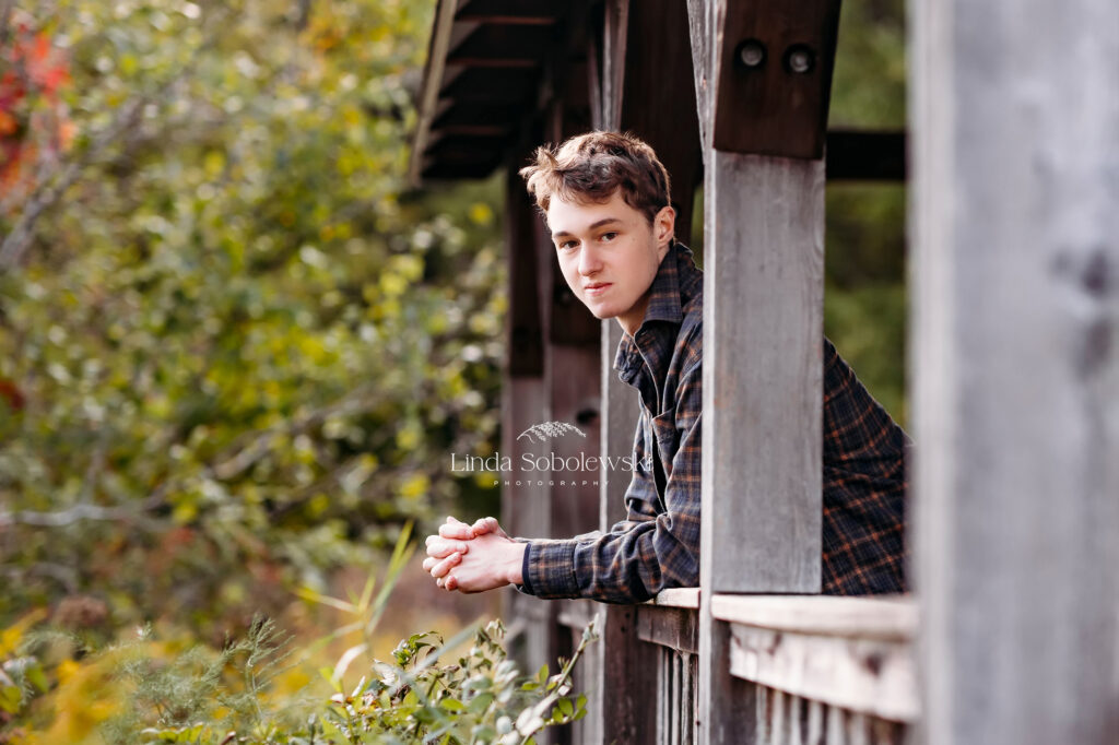 teenage boy leaning against a bridge, CT Shoreline senior photographer