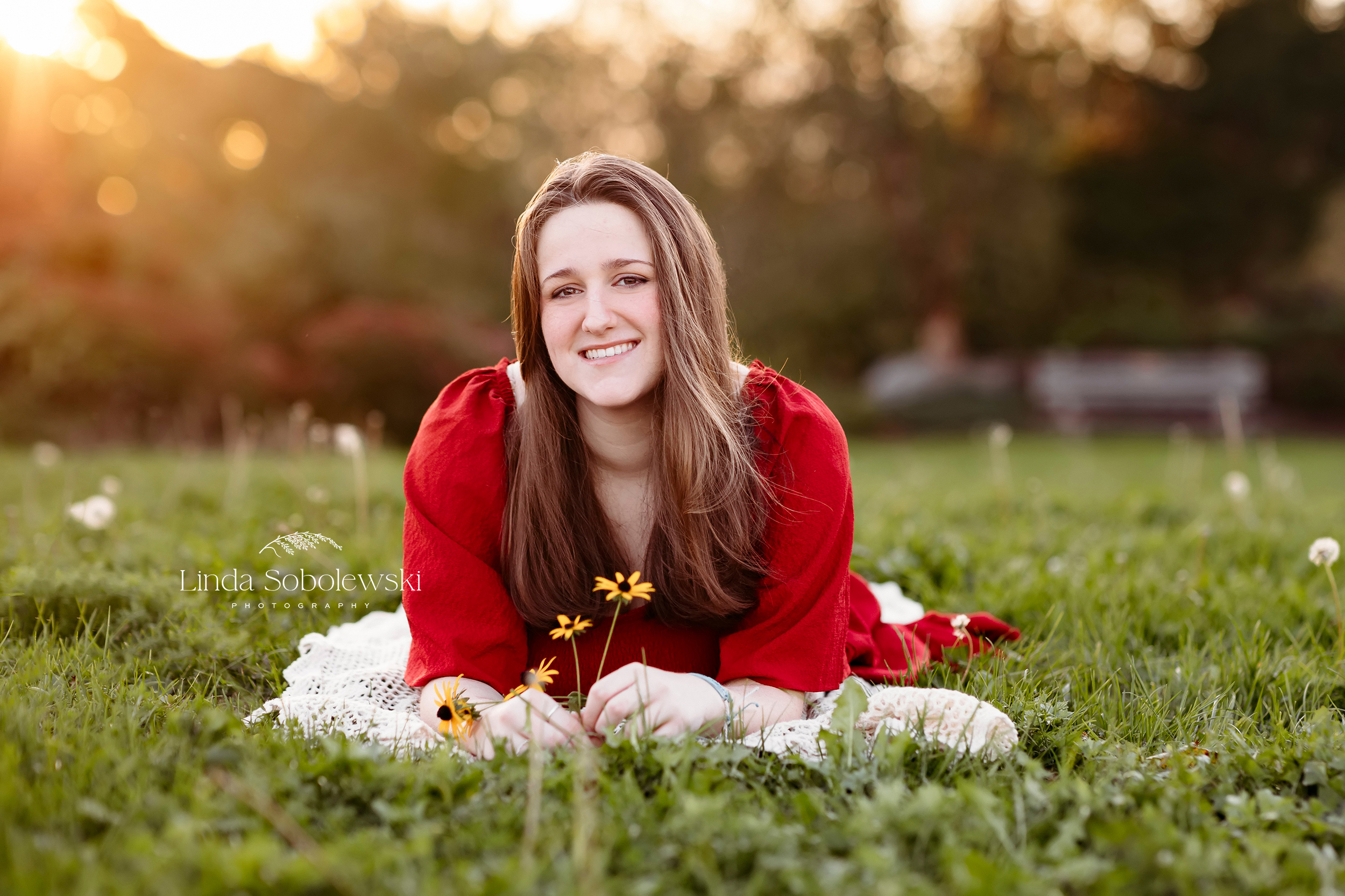 girl in red dress laying in the grass, Founders Park senior photo session