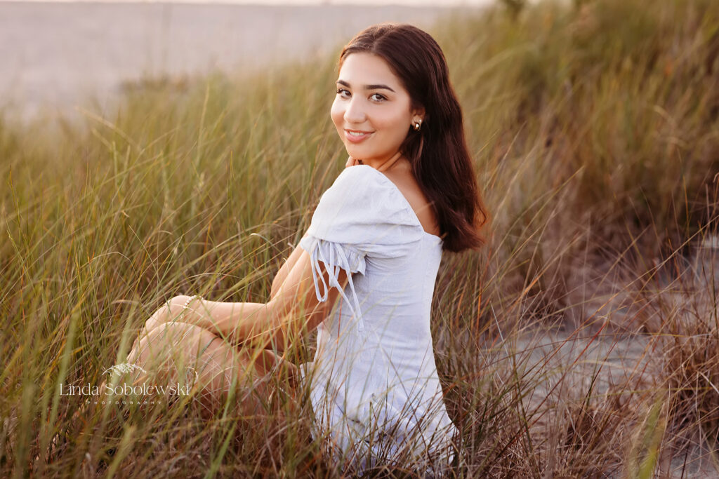 teenage girl in blue dress sitting in a field of grasses, CT High School senior photography