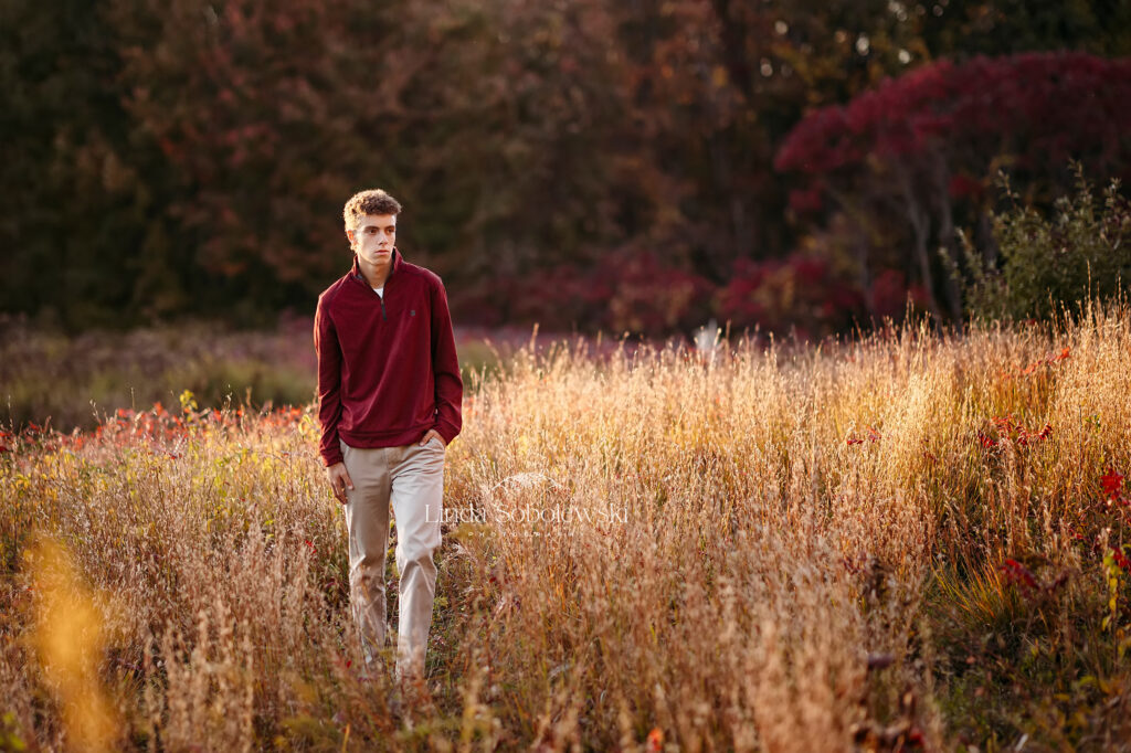 young man in red sweater standing in a field, CT Shoreline senior boy photo session