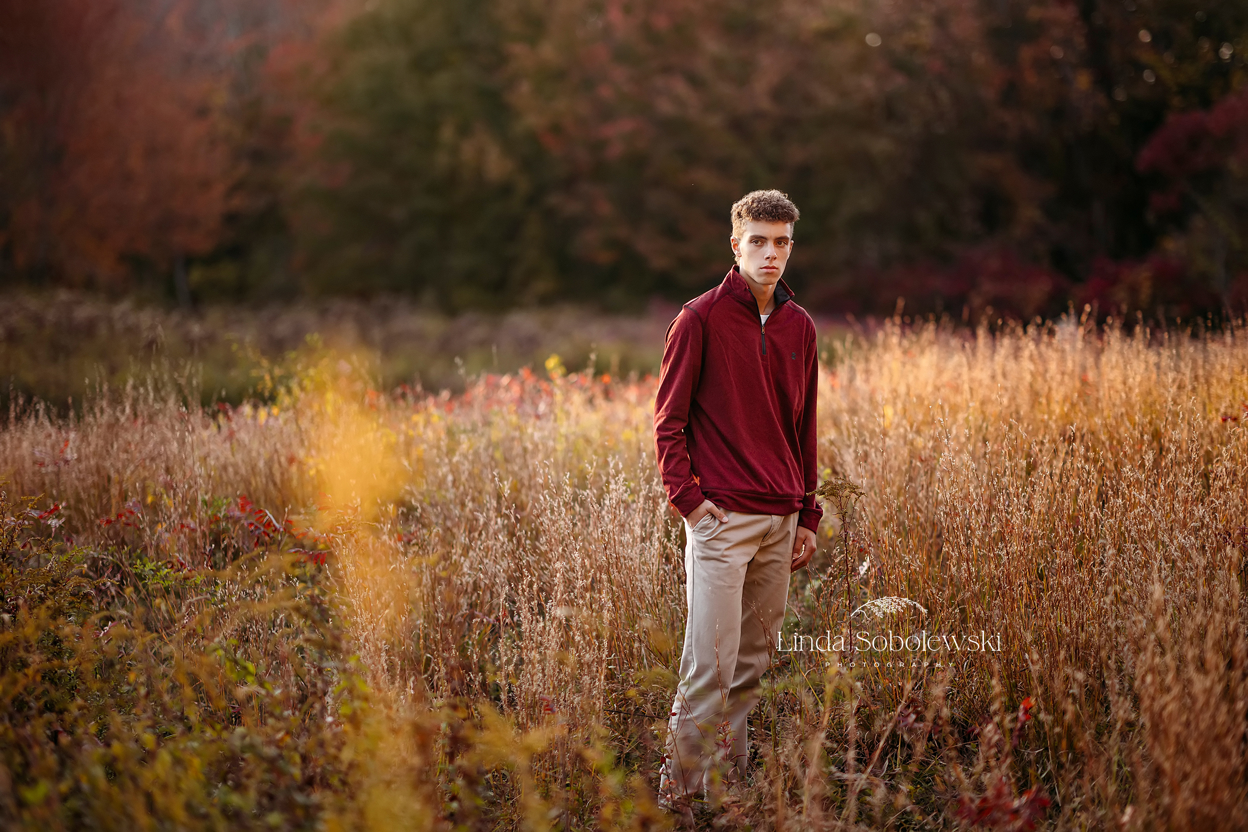 boy in red shirt standing in a field, CT Best senior photographer
