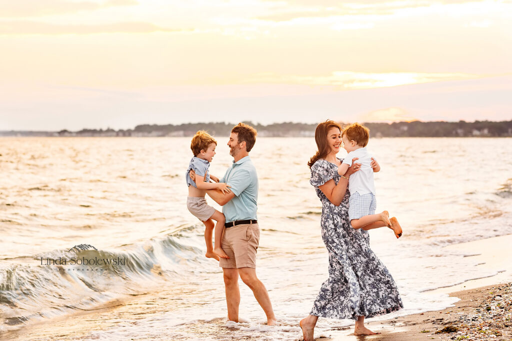 family of four twirling around and playing at the beach, CT Family photographer