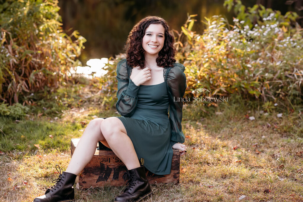 girl in green dress sitting on a box at a park, Senior girl photos with a CT shoreline photographer