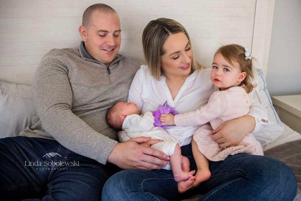 family with two babies together in bed, Old Saybrook newborn photographer