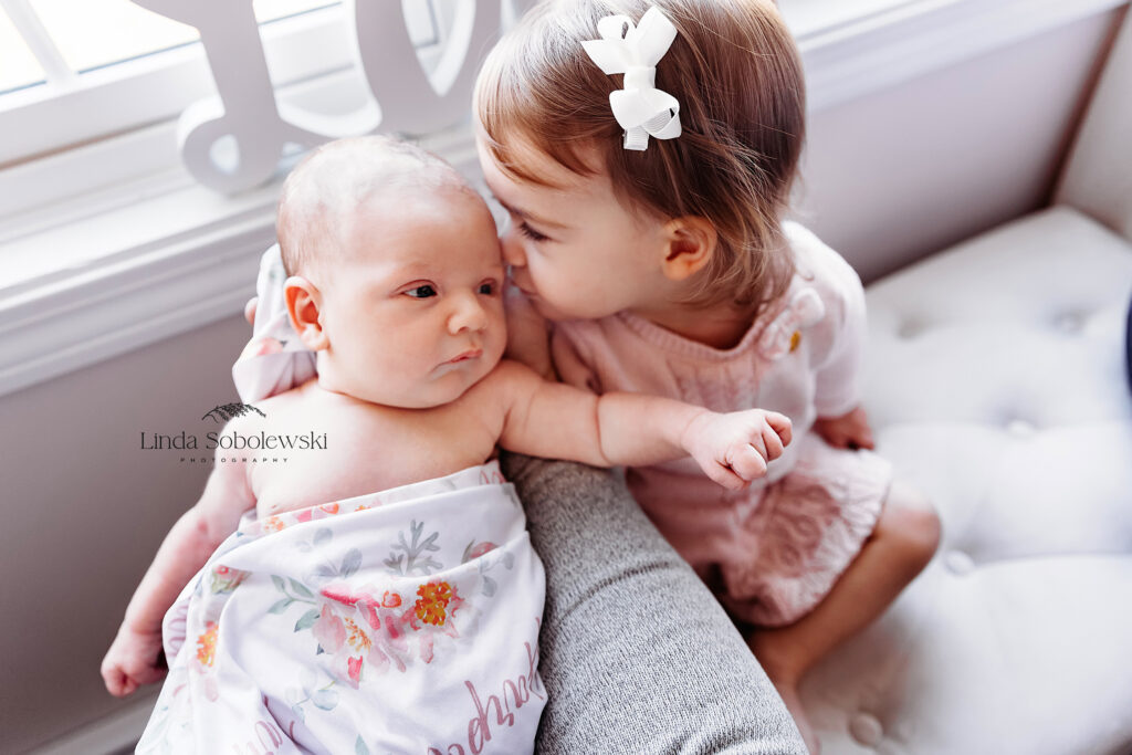 toddler girl kissing her newborn sister, Best photographer in CT