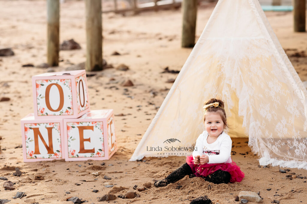 baby in red skirt at the beach for her first birthday photo shoot, Photos for Baby's First Birthday with CT photographer