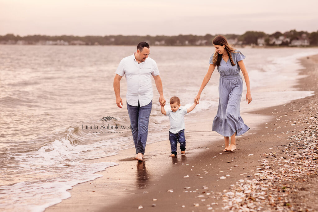 family of three walking together on the beach, Best family photographer in CT