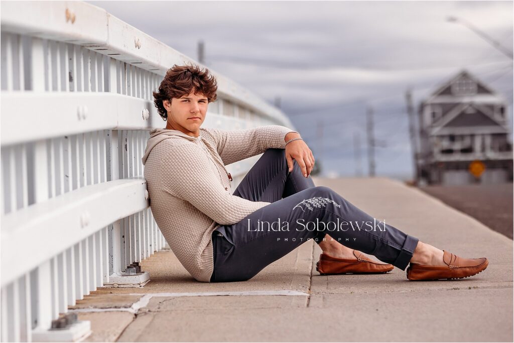 teenage boy sitting on the sidewalk for his senior photos, CT photographer