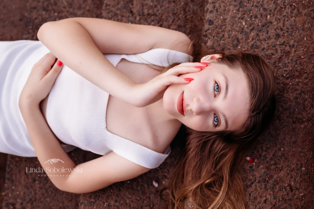 girl in white dress laying on steps, Senior photo session at Elizabeth State Park in Hartford CT