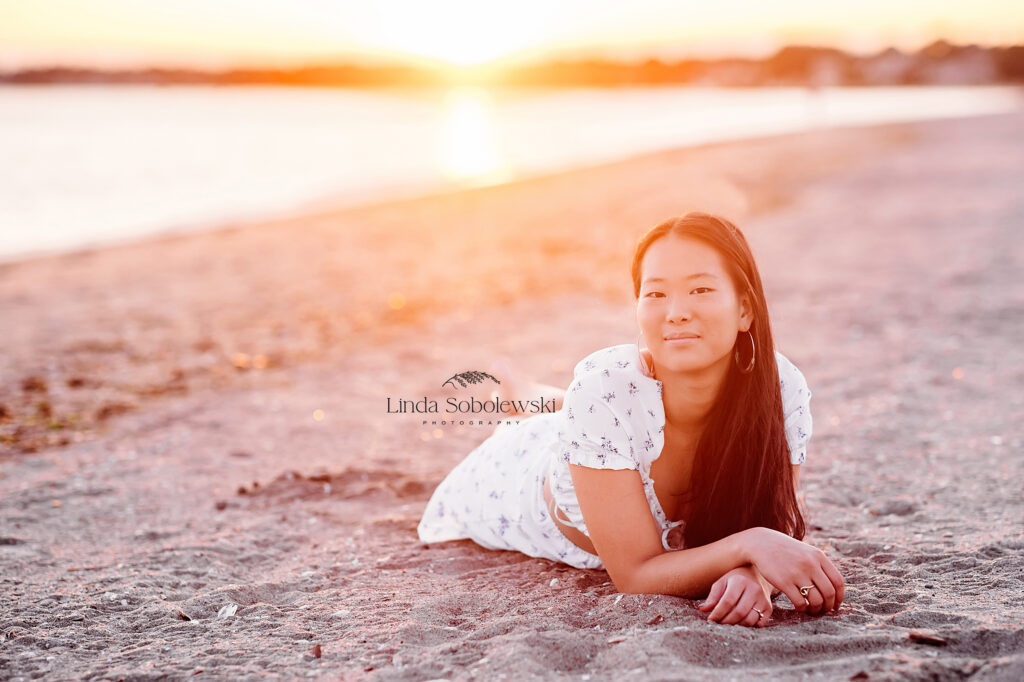 teenage girl laying on the beach during sunset, CT Senior photographer