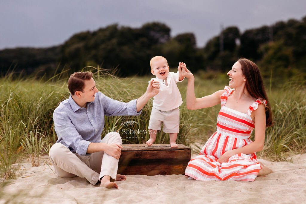 mom and dad holding their baby boy at the beach for beautiful family photos, East Lyme, CT photographer