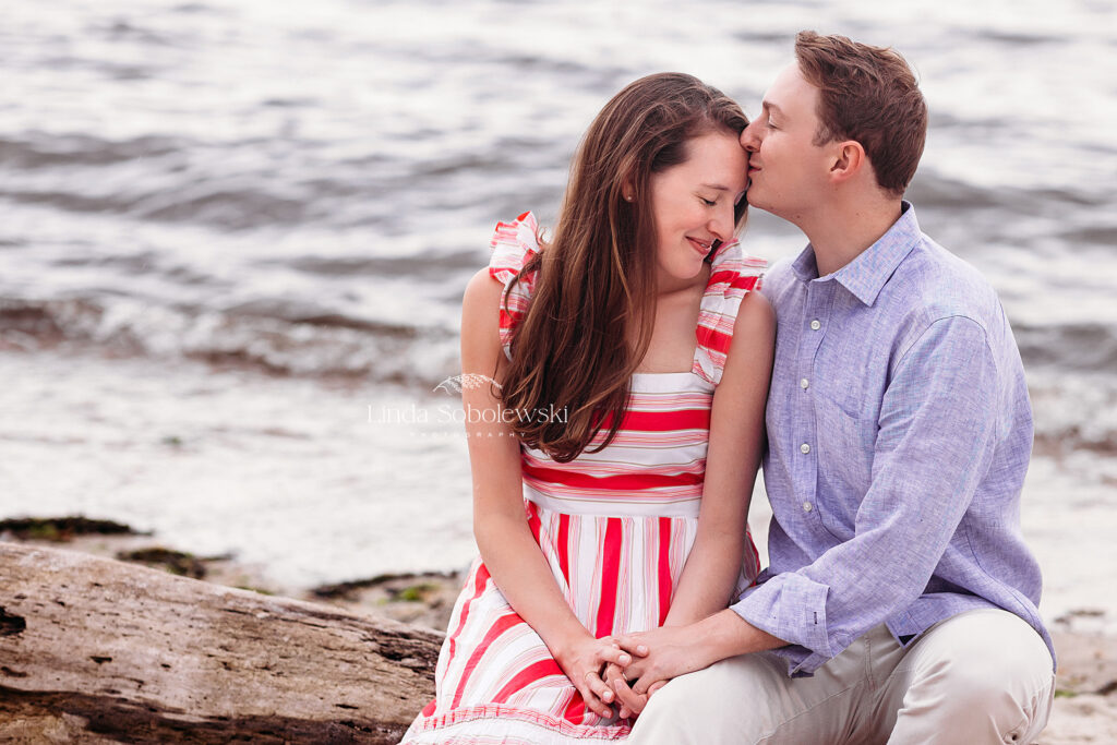husband kissing his wife at the beach, CT shoreline family and senior photographer