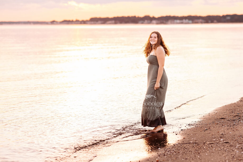 girl in green dress walking in the water at the beach, CT shoreline senior photographer