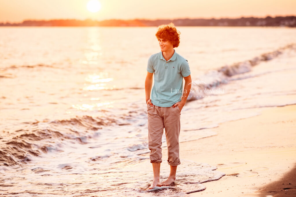 teenage boy in green shirt walking on the beach, CT twins senior pictures