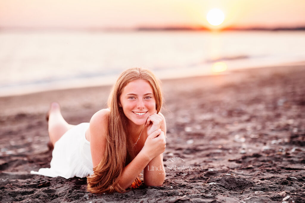 beautiful girl in white dress laying on the beach, CT senior photographer