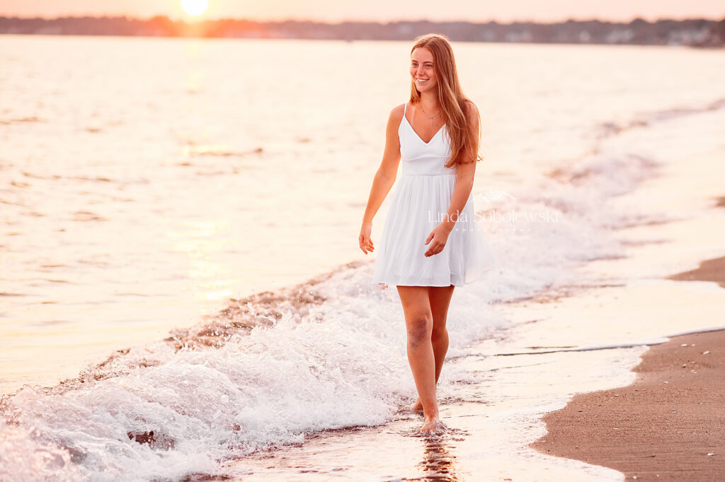 girl in white dress walking in the water at the beach, CT Shoreline best senior photographer