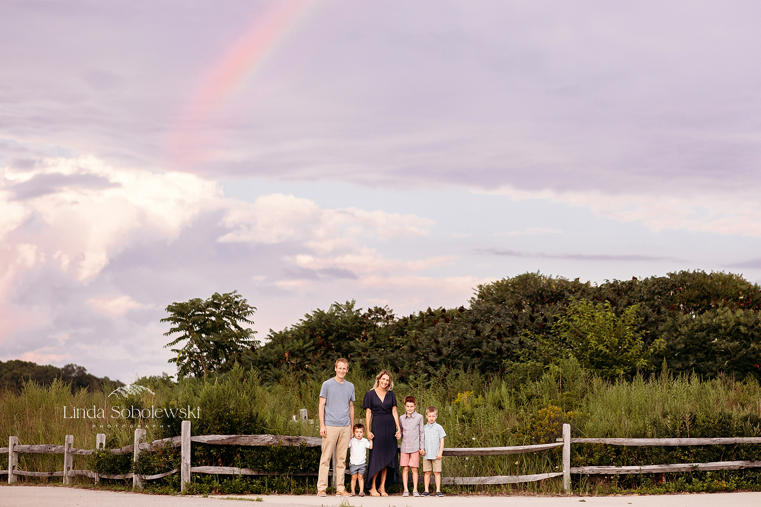 family of five standing with a beautiful rainbow, Family photos at the beach in Hammonasset CT